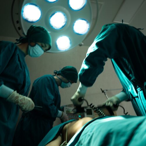 professional surgery team in the operating room, urgent surgery. Professional smart intelligent surgeons standing near the patient and performing an operation while saving his life Cateterismo